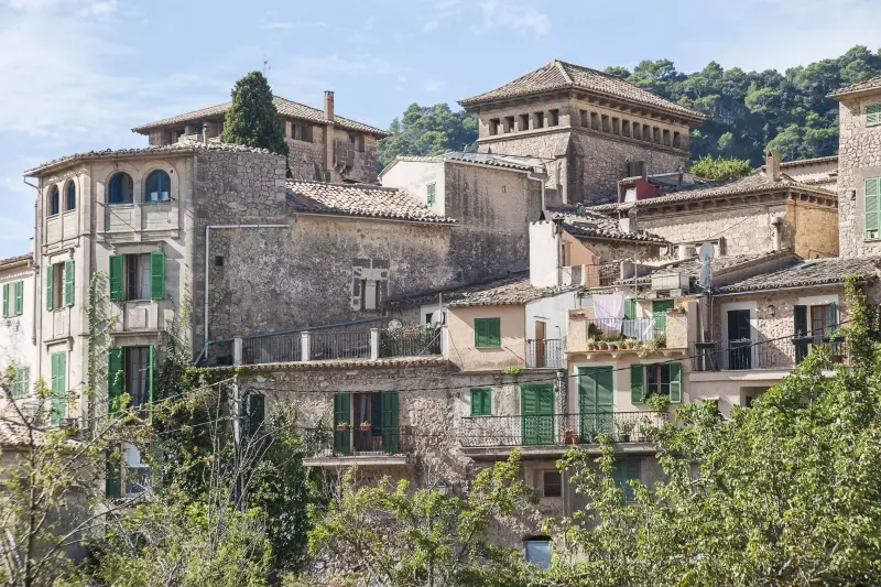 Mallorquinisches Bergdorf vor bewaldeten Bergen