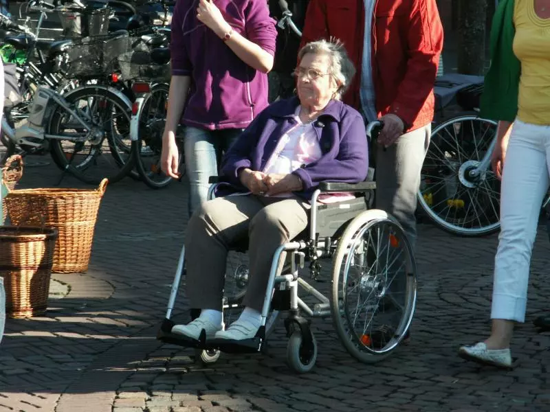 Person im Rollstuhl mit Begleitung